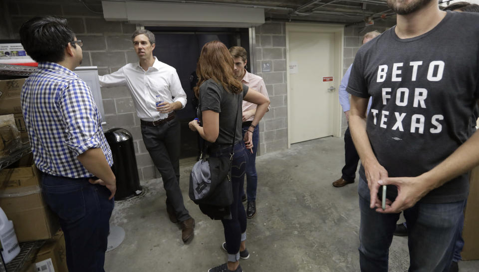 In this Tuesday, Oct. 2, 2018 photo, Democratic Senate candidate Rep. Beto O'Rourke, second from left, visits with staff and guests backstage following a campaign stop at Austin Community College Eastview, in Austin, Texas. O'Rourke has risen to national prominence on a workaday image that aligns closely with his politics but not his family's actual finances. (AP Photo/Eric Gay)