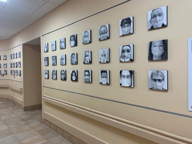 Photos of masked Portsmouth Regional Hospital employees line the hallway on the first floor of the hospital. The photo installation was designed to celebrate the contributions and commitment made by hospital staff every day to care for their patients, colleagues, and communities.