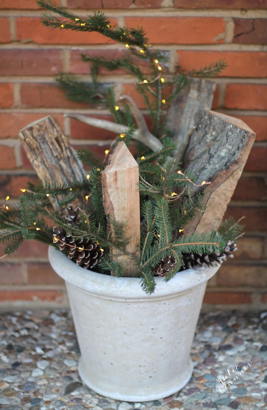 <p>Turn a common winter scene — firewood, evergreen branches, and pinecones — into a dazzling display with some string lights.</p><p>See more at <a href="http://julieblanner.com/fall-to-winter-decorations/" rel="nofollow noopener" target="_blank" data-ylk="slk:Julie Blanner;elm:context_link;itc:0;sec:content-canvas" class="link ">Julie Blanner</a>. </p>