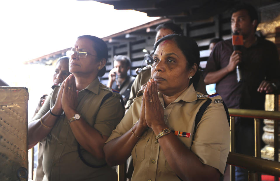 In this Monday, Nov. 5, 2018, photo, Indian policewomen, above the age of 50, offer prayers at Sabarimala temple, one of the world's largest Hindu pilgrimage sites, in the southern Indian state of Kerala, India. Reports of two women of menstruating age, or between the age of 10 to 50, entering the temple on Wednesday, Jan. 2, have lead to protests across the state. India's Supreme Court on Sept. 28, 2018 lifted the ban on women of menstruating age from entering the temple, holding that equality is supreme irrespective of age and gender. (AP Photo/Manish Swarup)