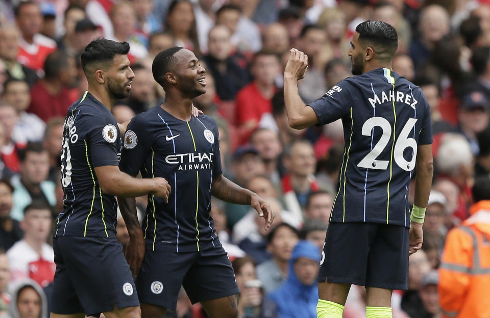 Manchester City's Raheem Sterling, center, celebrates with Sergio Aguero and Riyad Mahrez, right, after scoring the opening goal during the English Premier League soccer match between Arsenal and Manchester City at the Emirates stadium in London, England, Sunday, Aug. 12, 2018. (AP Photo/Tim Ireland)