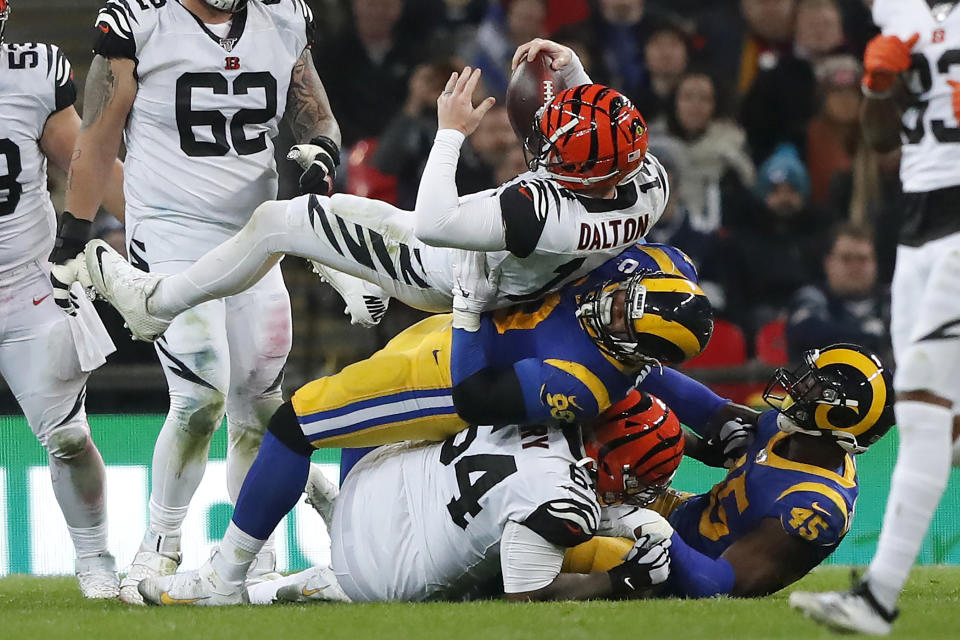 Cincinnati Bengals quarterback Andy Dalton, top, is sacked by Los Angeles Rams defensive tackle Aaron Donald during the second half of an NFL football game, Sunday, Oct. 27, 2019, at Wembley Stadium in London. (AP Photo/Frank Augstein)