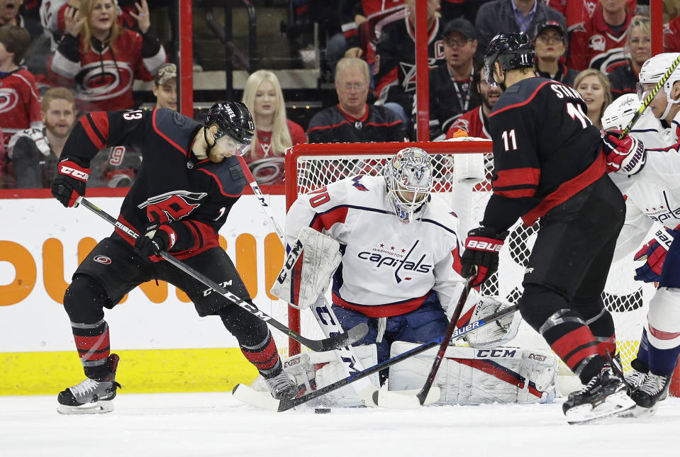 Carolina Hurricanes' Warren Foegele (13) tries to score against Washington Capitals goalie Braden Holtby (70) while Hurricanes' Jordan Staal (11) assists during the first period of Game 6 of an NHL hockey first-round playoff series in Raleigh, N.C., Monday, April 22, 2019. (AP Photo/Gerry Broome)