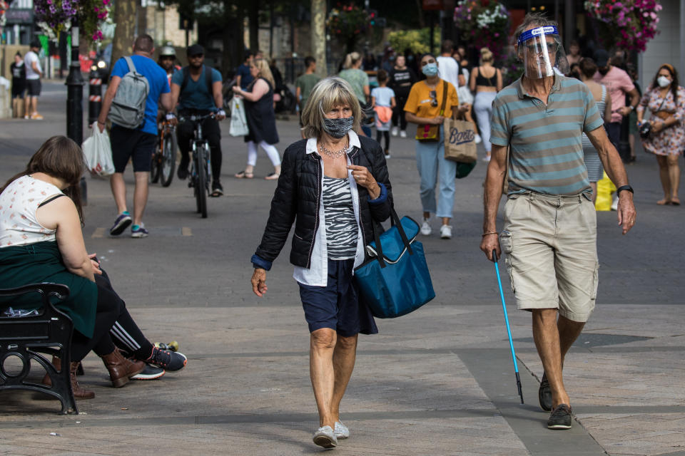 Shoppers wear face coverings and a visor to help prevent the spread of the coronavirus on 20 September 2020 in Staines-Upon-Thames, United Kingdom. The Borough of Spelthorne, of which Staines-upon-Thames forms part along with Ashford, Sunbury-upon-Thames, Stanwell, Shepperton and Laleham, has been declared an area of concern for COVID-19 by the government following a marked rise in coronavirus infections which is inconsistent with other areas of Surrey. (photo by Mark Kerrison/In Pictures via Getty Images)