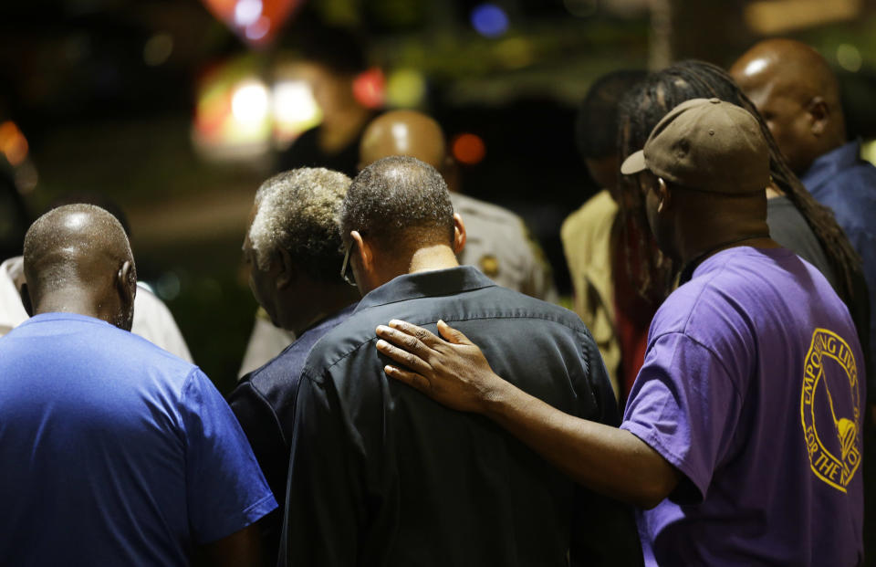 Worshippers gather to pray in a hotel parking lot across the street from the Emanuel AME Church (AP Photo/David Goldman)