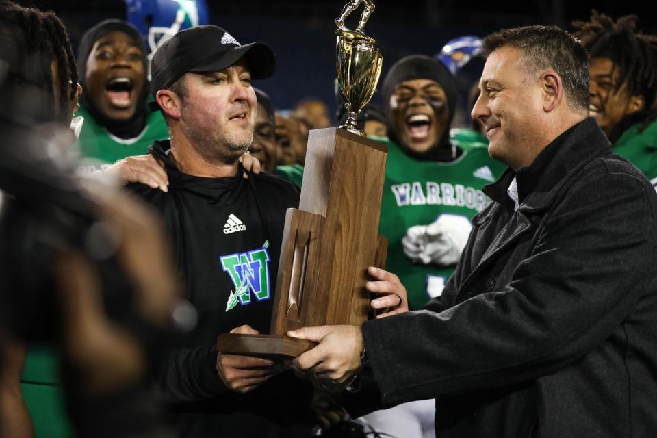 Winton Woods head coach Chad Murphy receives the first place trophy following his win following the OHSAA Division II state game between the Cincinnati Winton Woods Warriors and the Akron Archbishop Hoban Knights at Tom Benson Hall of Fame Stadium.  The Warriors lead the game at halftime by a score of 14-3.