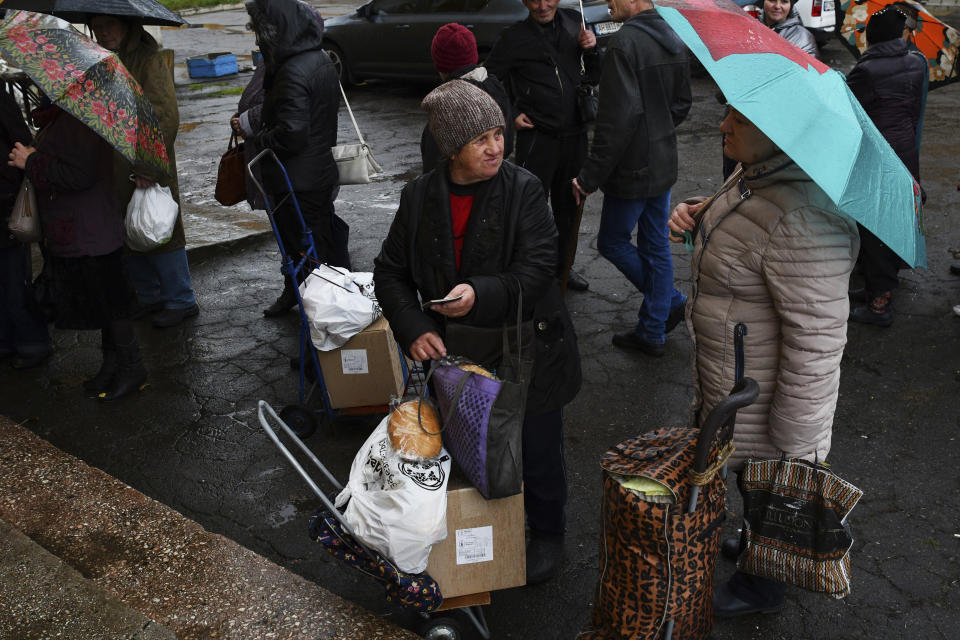 People receive bread at humanitarian aid center in Kramatorsk, Ukraine, Wednesday, Oct. 26, 2022. (AP Photo/Andriy Andriyenko)
