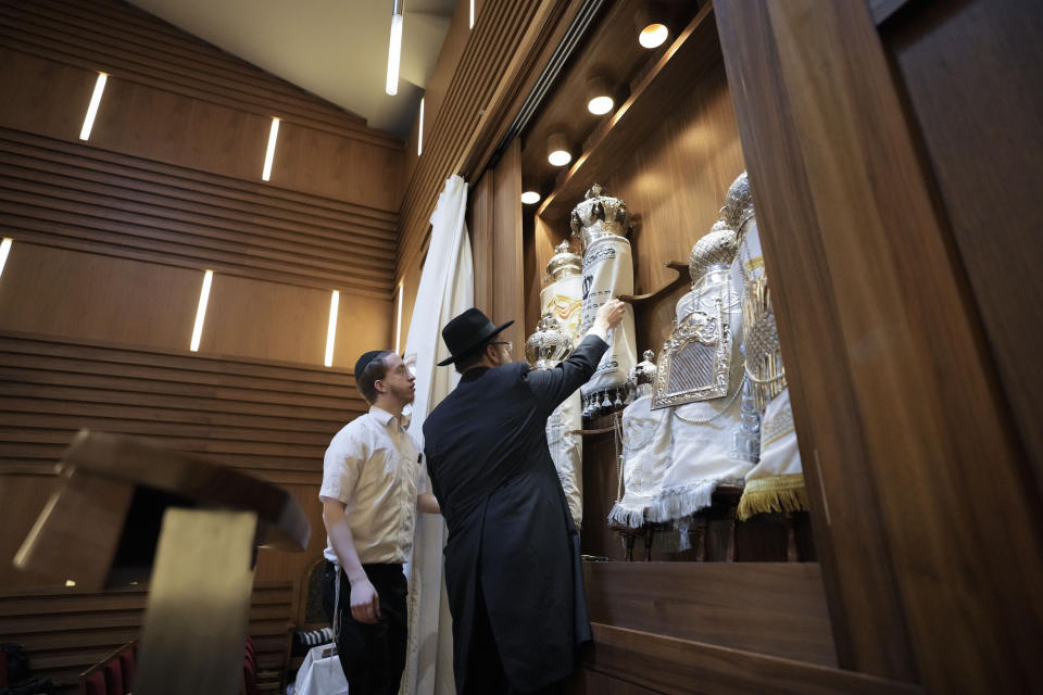 Rabbi Yehuda Teichtal, right, prepares Torah scrolls at the synagogue of the Chabad community prior to the first Shabbat service after the Hamas attacks on Israel, in Berlin, Germany, Friday, Oct. 13, 2023. (AP Photo/Markus Schreiber)