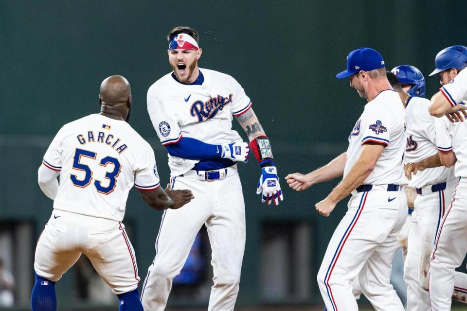 Texas Rangers catcher Jonah Heim (28) celebrates with his teammates after hitting a walk off single at the bottom of the tenth inning to win their season opener against the Chicago Cubs 4-3 at Globe Life Field in Arlington on Thursday, March 28, 2024. Chris Torres/ctorres@star-telegram.com