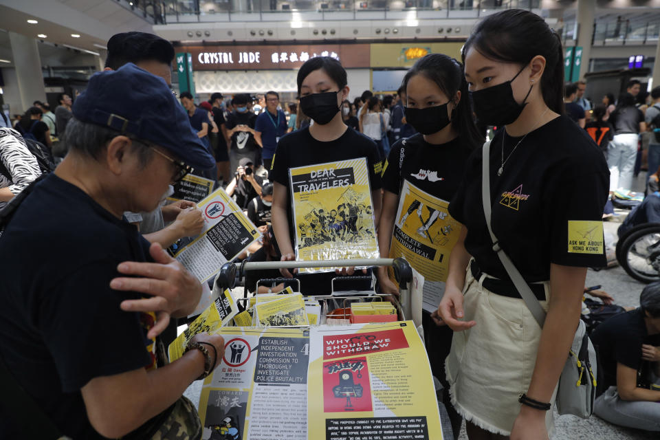 Protesters promote their cause at the airport In Hong Kong on Friday, Aug. 9, 2019. Pro-democracy protesters held a demonstration at Hong Kong's airport Friday even as the city sought to reassure visitors to the city after several countries issued travel safety warnings related to the increasing levels of violence surrounding the two-month-old protest movement. (AP Photo/Vincent Thian)