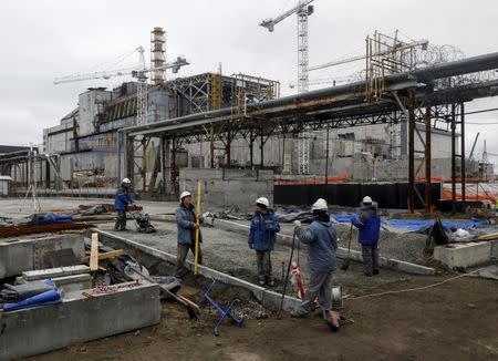 Employees work in front of the sarcophagus covering the damaged fourth reactor at the Chernobyl nuclear power plant, Ukraine, March 23, 2016. REUTERS/Gleb Garanich