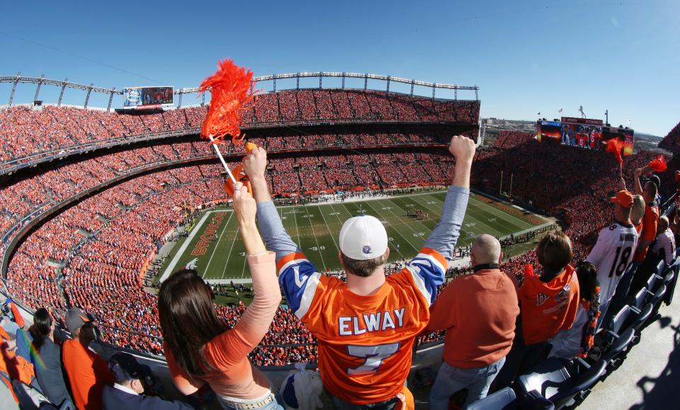 Denver Broncos fans cheer as the AFC championship NFL football playoff game between the Broncos and the New England Patriots was about to start, Jan. 19, 2014, in Denver. The Walton family has won the bidding to purchase the Broncos in the most expensive deal for a sports franchise anywhere in the world.