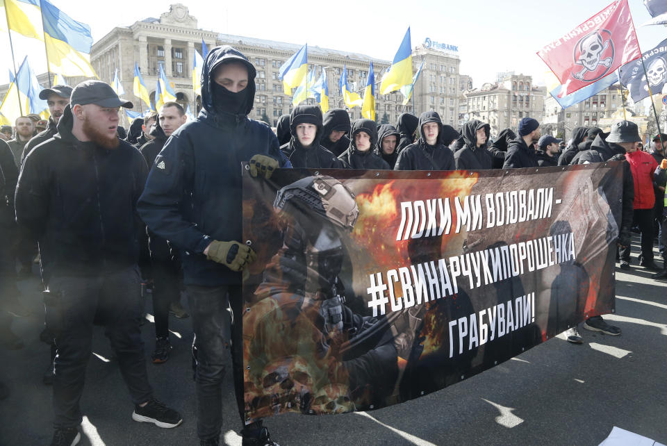 Far-right demonstrators attend rally against corruption in downtown Kiev, Ukraine, Saturday, March 23, 2019. The placard reads "While we fought, the Svinarchuk and Poroshenko robbed". (AP Photo/Efrem Lukatsky)