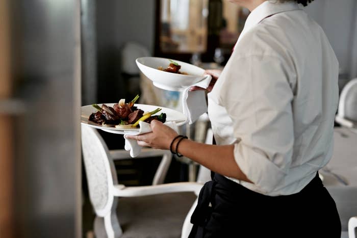 server carrying plates out to a table