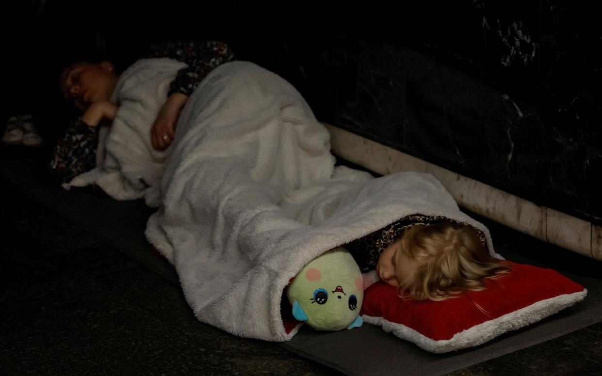 A girl shelters in a metro station with her family during the overnight attacks