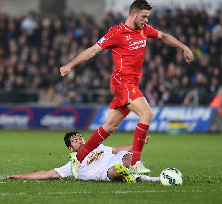 Liverpool's English midfielder Jordan Henderson (R) controls the ball before scoring during a match against Swansea City on March 16, 2015, in Swansea, south Wales