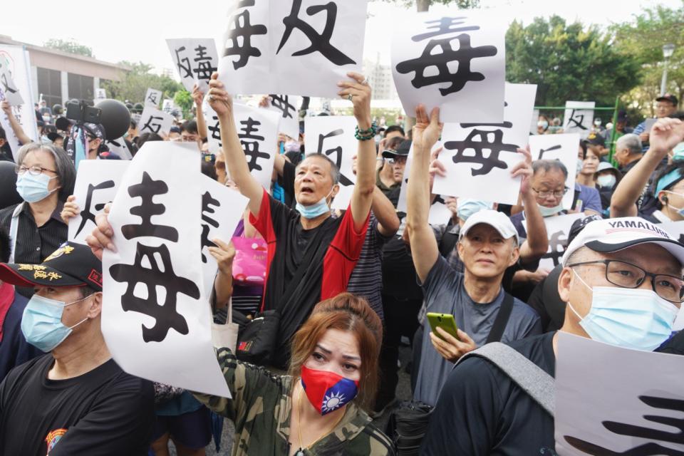 多位參加秋鬥遊行的藍營支持者在遊行終點—民進黨中央黨部前，高舉「毒」與「反」的手舉牌，反對蔡英文政府開放含萊克多巴胺劑的美豬進口。   圖：張良一/攝