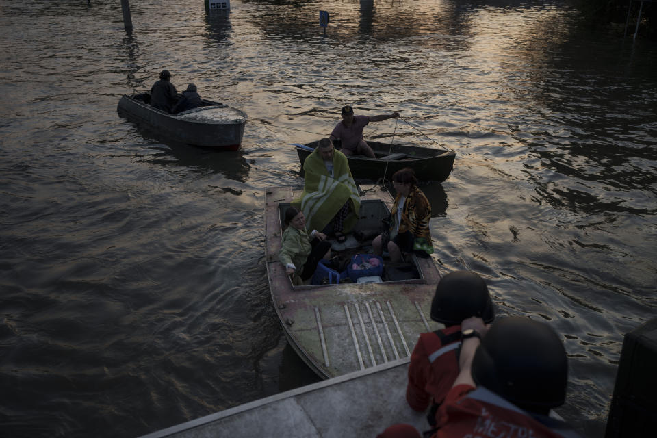 Trabajadores de rescate tratan de remolcar barcos con residentes evacuados a bordo, en Jersón, Ucrania, el martes 6 de junio de 2023. (AP Foto/Felipe Dana)