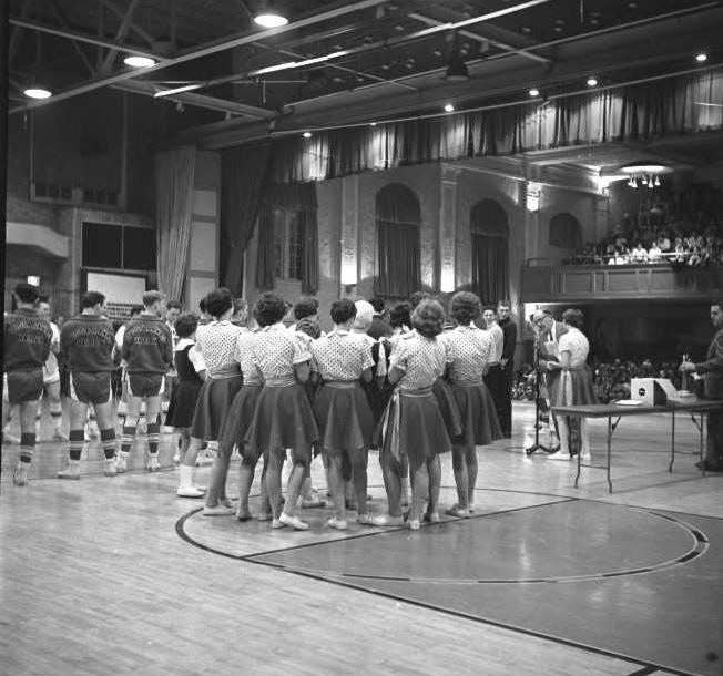 Cheerleaders and players are shown at a Tuscarawas Valley High School basketball game in the late 1950s.