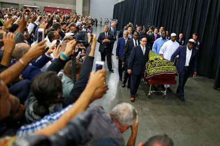 Worshipers and well-wishers take photographs as the casket with the body of Muhammad Ali is brought for his jenazah. REUTERS/Carlos Barria