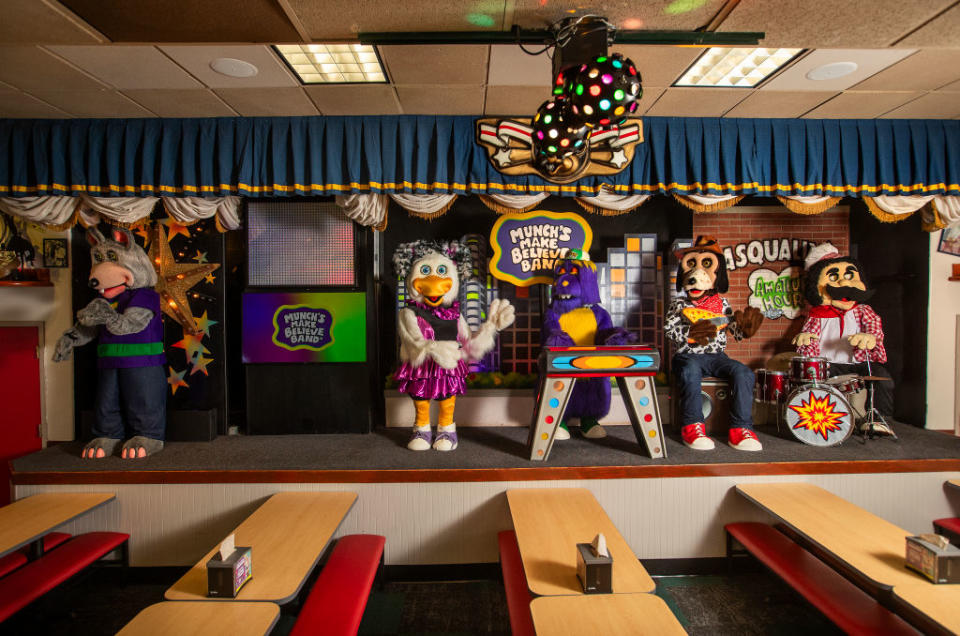 Animated band characters on stage at Chuck E. Cheese's, with Chuck E. at center and others playing instruments