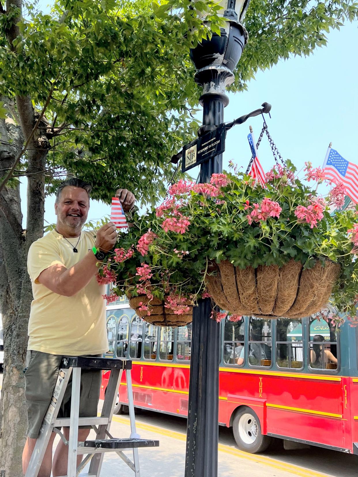 Newport in Bloom member Paul Galluscio seen planting miniature American flags.