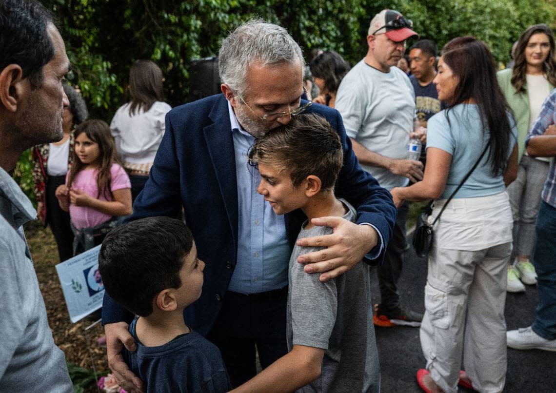 Majdi Abou Najm, whose son Karim Abou Najm was fatally stabbed in Sycamore Park one year ago, is greeted by children of the Davis community on Monday at a “Day of Remembrance” event where a memorial was unveiled.