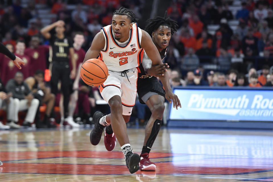 Syracuse guard J.J. Starling, left, dribbles away from pressure by Florida State forward Jamir Watkins during the second half of an NCAA college basketball game in Syracuse, N.Y., Tuesday, Jan. 23, 2024. (AP Photo/Adrian Kraus)