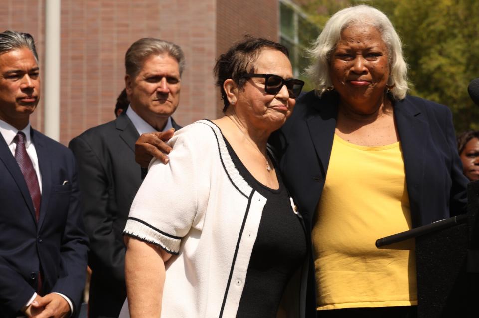 Two women stand side by side.