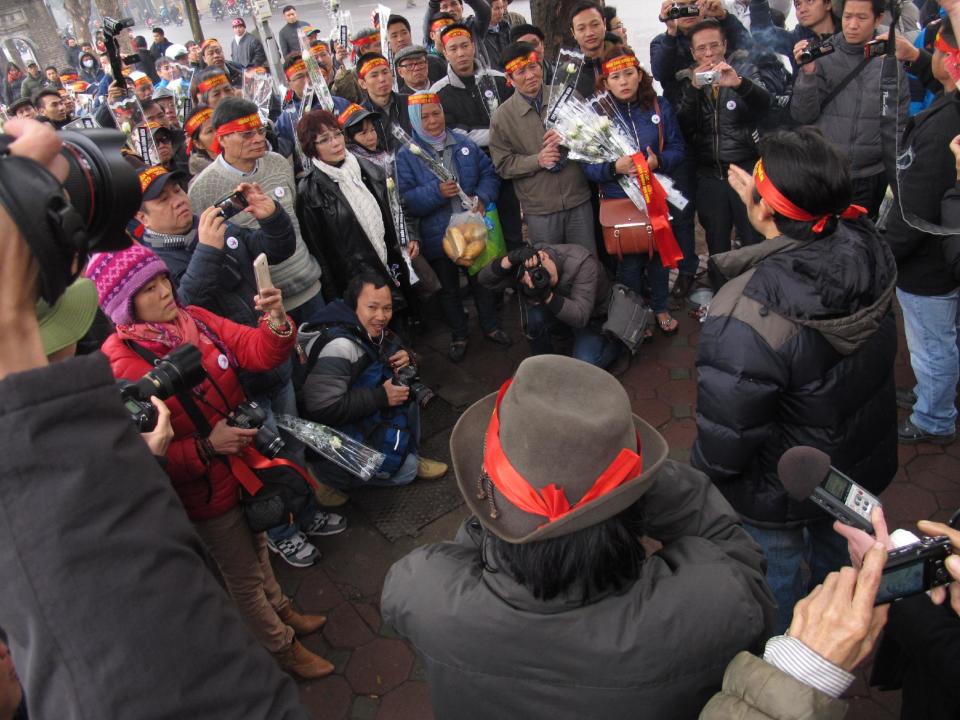 Anti-China protestors and citizen journalists gather around an activist making a speech in the Vietnamese capital Sunday, Feb. 16, 2014. The protestors were marking the 35th anniversary of a border war between Vietnam and China. Vietnam is wary of all forms of public protest and often quashes anti-China gatherings (AP Photo/Chris Brummitt)