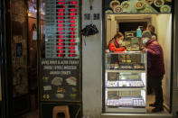 A seller attends a client in a gold shop next to a currency exchange post at the Grand Bazaar in Istanbul, Turkey, Wednesday, Jan. 12, 2022. Turkey's government and central bank have taken a series of complex steps in recent weeks to prop up a beleaguered economy crippled by skyrocketing consumer prices, instead of ending a much-criticized plan to cut interest rates. (AP Photo/Francisco Seco)