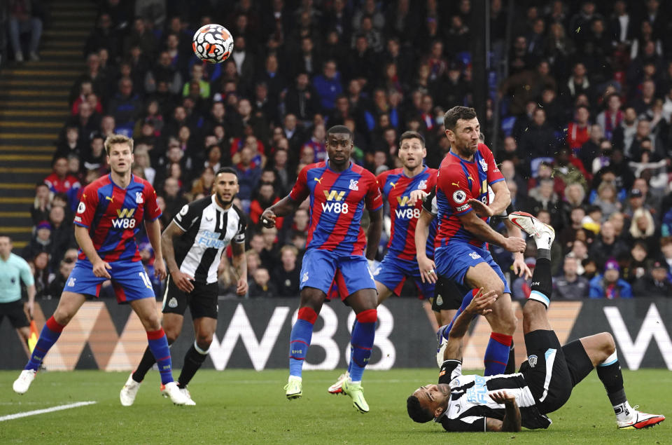 Newcastle United's Callum Wilson, on the ground at right, scores during the English Premier League soccer match between Crystal Palace and Newcastle United at Selhurst Park, London, Saturday Oct. 23, 2021. (Jonathan Brady/PA via AP)