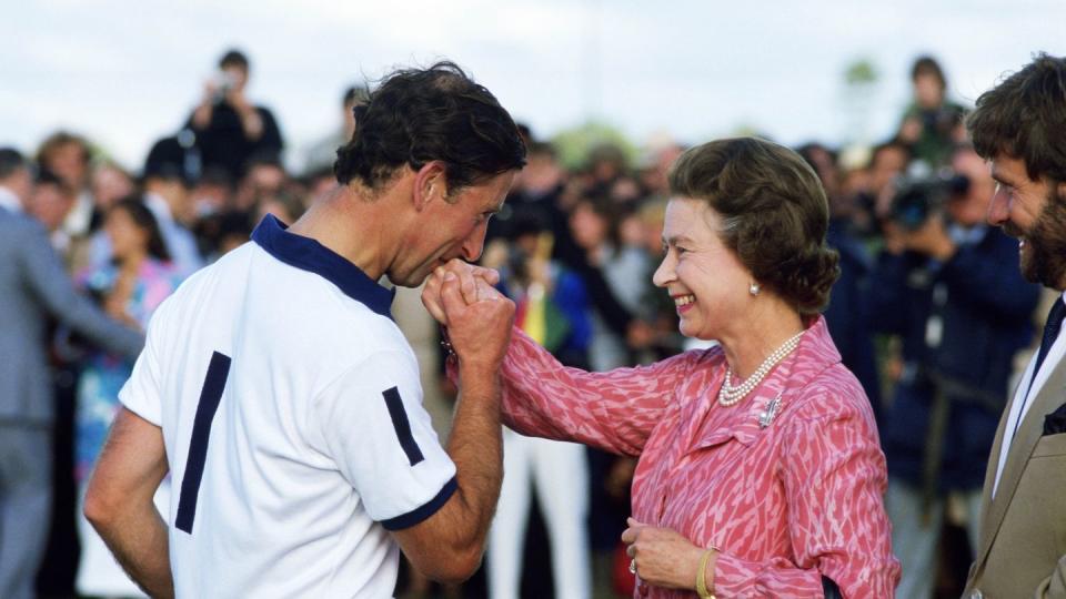 prince charles kisses the hand of his mother, queen elizabet