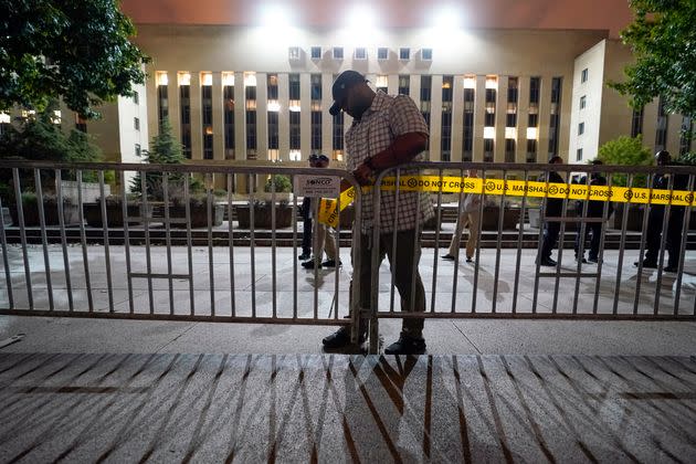 Workers put up barricades and secure the area outside the E. Barrett Prettyman U.S. Courthouse.