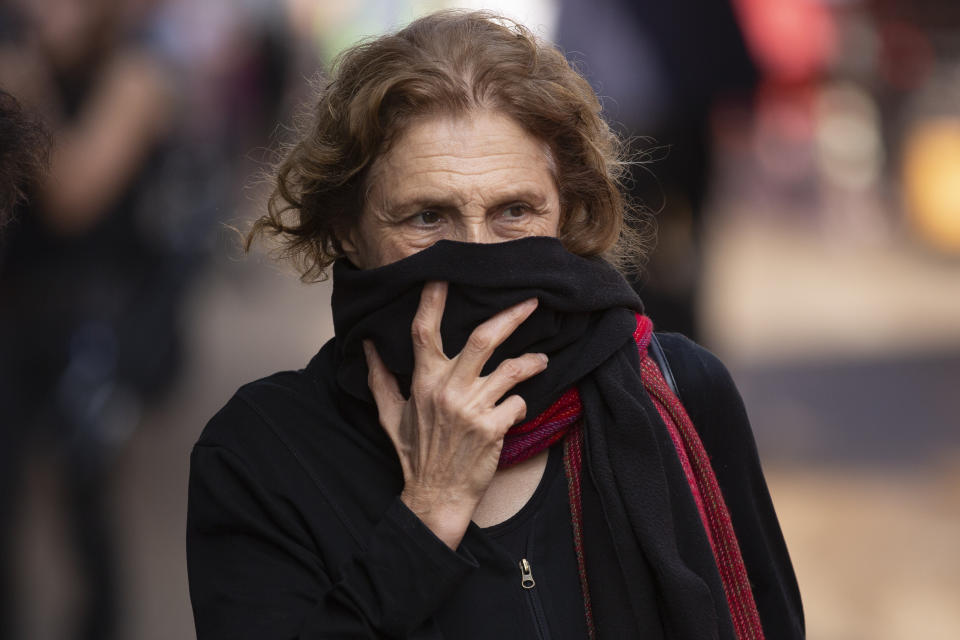 A woman covers her face as she shops at a food market in Tel Aviv, Israel, Sunday, March 15, 2020. ‏Israel has imposed a number of tough restrictions to slow the spread of the new coronavirus. Prime Minister Benjamin Netanyahu announced that schools, universities, restaurants and places of entertainment will be closed to stop the spread of the coronavirus. He also encouraged people not to go to their workplaces unless absolutely necessary. (AP Photo/Oded Balilty)