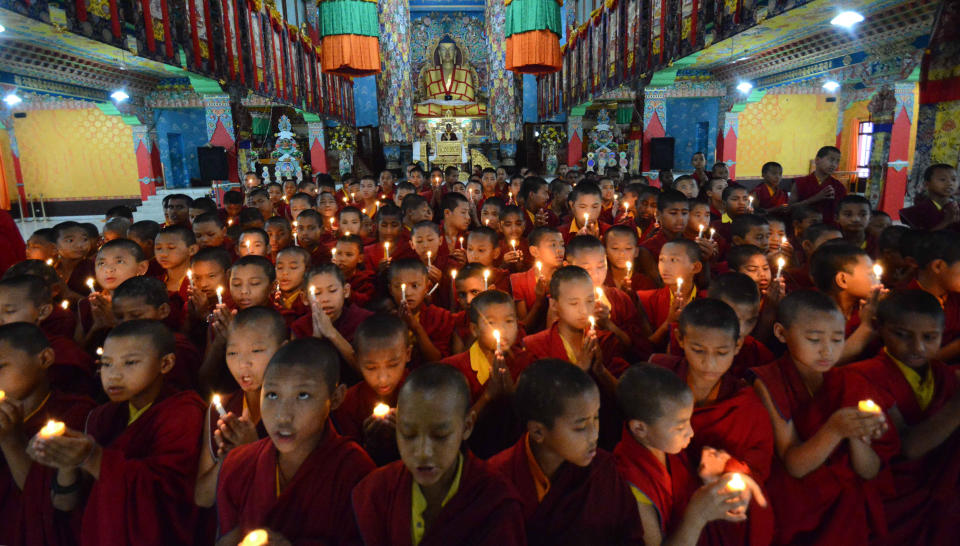 Novice Buddhist monks light candles and offer prayers for victims of Nepal's earthquake, in Bodhgaya, India, Sunday, April 26, 2015. (AP Photo/Manish Bhandari)