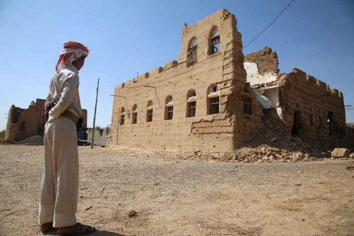 A Yemeni man stands next to a building destroyed in clashes between fighters from the Popular Resistance Committees and Shiite Huthi rebels in the village of Faw on the road to Marib province, on October 14, 2015 (AFP Photo/Abdullah al-Qadry)