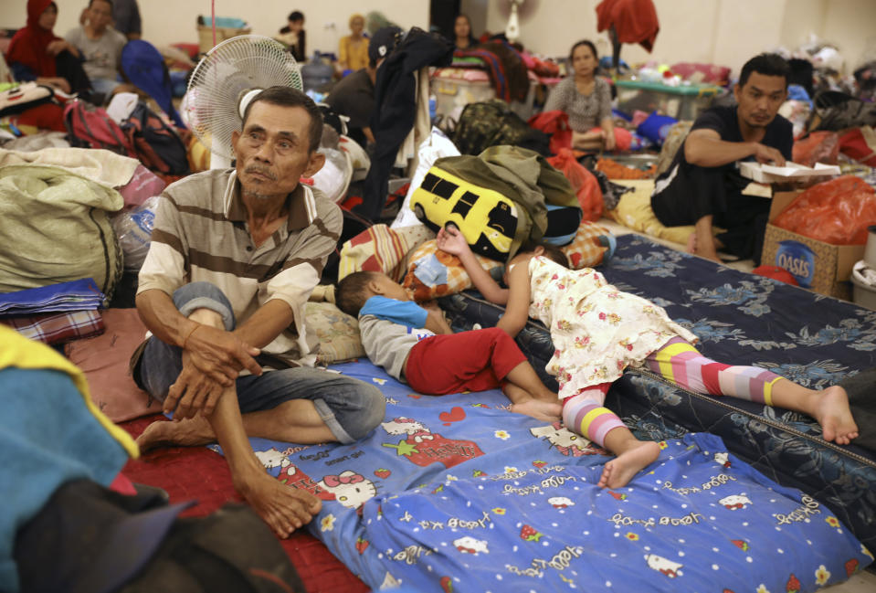 People rest at a temporary shelter for those affected by the floods in Jakarta, Indonesia, Friday, Jan. 3, 2020. Severe flooding in the capital as residents celebrated the new year has killed dozens of people and displaced hundreds of thousands others. (AP Photo/Dita Alangkara)