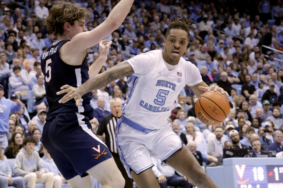 FILE - North Carolina forward Armando Bacot, right, drives against Virginia forward Ben Vander Plas, left, during the first half of an NCAA college basketball game, Feb. 25, 2023, in Chapel Hill, N.C. The North Carolina Tar Heels are ranked No. 19 in the preseason AP Top 25. (AP Photo/Chris Seward, File)