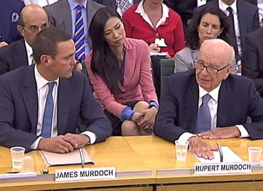 Rupert Murdoch's wife Wendi Deng (C) looks on as BSkyB Chairman James Murdoch and News Corp Chief Executive and Chairman Rupert Murdoch (R) appear before a parliamentary committee on phone hacking at Portcullis House in London July 19, 2011. (REUTERS/Parbul TV via Reuters Tv)