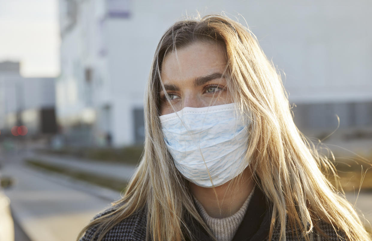 Young woman outside wearing a virus protective face mask