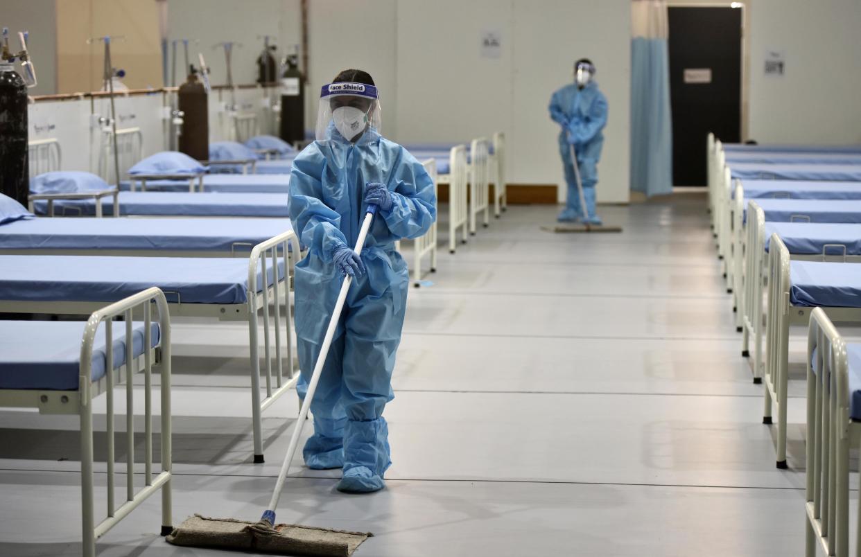 A worker wearing personal protective equipment cleans the COVID-19 care facility at Tau Devi Lal Stadium on May 27 in Gurugram, India. (Photo: Vipin Kumar/Hindustan Times via Getty Images)