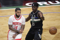 Houston Rockets' D.J. Augustin (14) passes the ball around Milwaukee Bucks' Jrue Holiday (21) during the first half of an NBA basketball game Friday, May 7, 2021, in Milwaukee. (AP Photo/Aaron Gash)