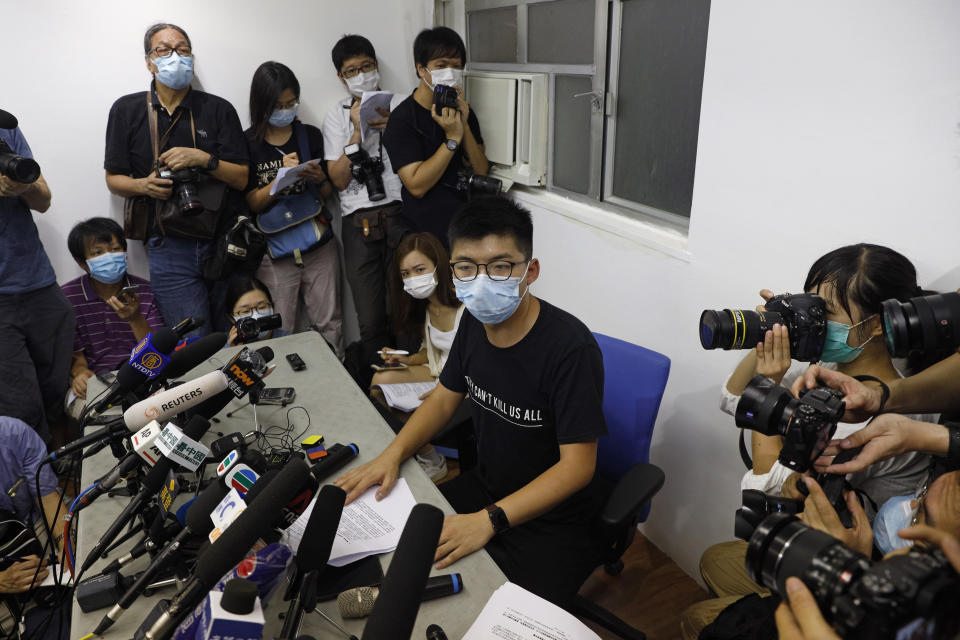 Hong Kong pro-democracy activist Joshua Wong, center, attends a press conference in Hong Kong, Friday, July 31, 2020. On Thursday, 12 pro-democracy candidates including prominent pro-democracy activist Joshua Wong were disqualified from running in the legislative elections, as they were deemed to not comply with the Basic Law or pledge allegiance to the city and Beijing.(AP Photo/Kin Cheung)