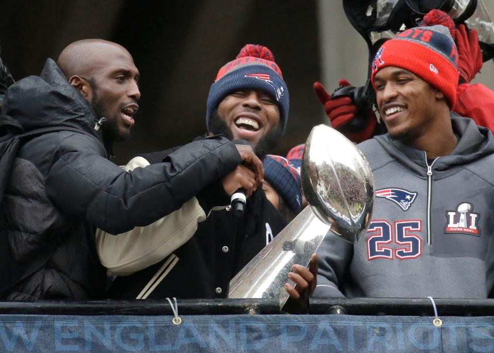 FILE - New England Patriots safety Devin McCourty, left, running back James White, center, and defensive back Eric Rowe (25) laugh with a Super Bowl trophy during a rally Tuesday, Feb. 7, 2017, in Boston, to celebrate Sunday's 34-28 win over the Atlanta Falcons in the NFL Super Bowl 51 football game in Houston. James White said Thursday, Aug. 11, 2022, he is retiring from the NFL. (AP Photo/Elise Amendola, File)