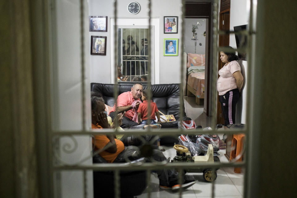 Victor Escobar is surrounded by family members after an interview in Cali, Colombia, Thursday, Jan. 6, 2022. Escobar, who suffers chronic obstructive pulmonary disease, oxygen dependence, lack of muscle control and secondary effects from a stroke is scheduled on the evening of Jan. 7 to become the first person to receive euthanasia legally, without being a terminally ill patient. Euthanasia for terminally ill patients is legal in Colombia. (AP Photo/Ivan Valencia)