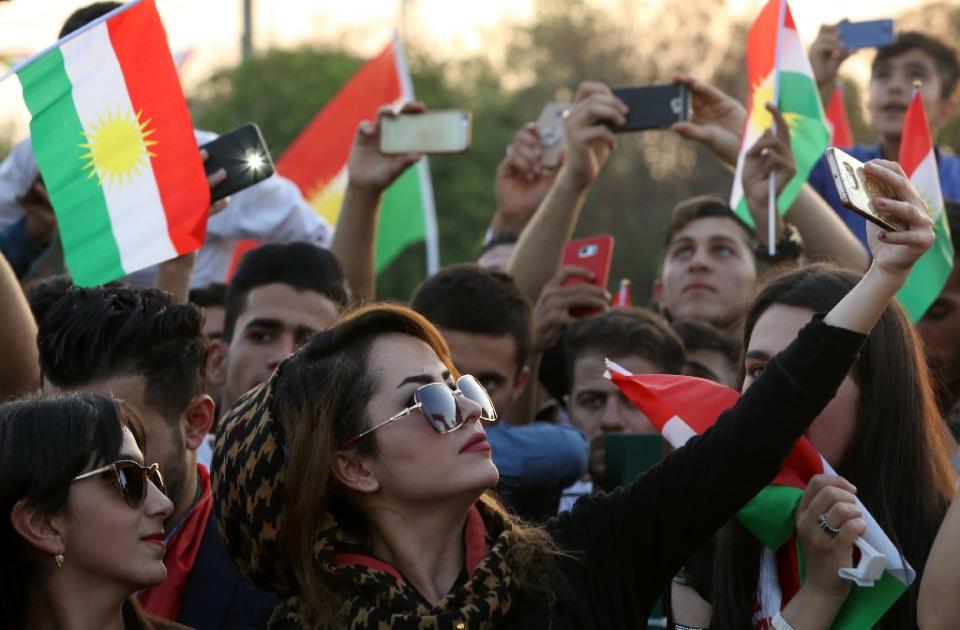 <p>An Iraqi Kurdish woman takes a selfie as people gather in the street flying Kurdish flags to urge fellow Kurds to vote in the upcoming independence referendum in Arbil, the capital of the autonomous Kurdish region of northern Iraq, Sept. 13, 2017. (Photo: Safin Hamed/AFP/Getty Images) </p>