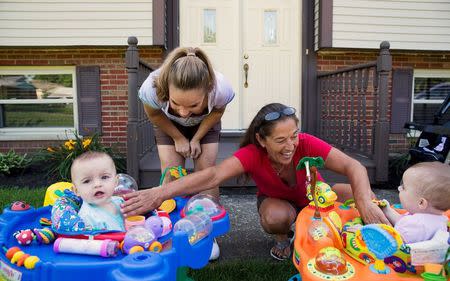 Heather Padgett, along with her mother Debi Padgett (R), plays with her daughters Kinsley and Kiley outside their home in Cincinnati, Ohio July 16, 2015. REUTERS/Aaron P. Bernstein