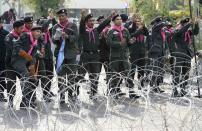 Thai riot police gesture to anti-government protesters as they welcome them inside their cordon after demonstrations were called off in Bangkok December 3, 2013. Thailand's government ordered police to stand down and allow protesters into state buildings on Tuesday, removing a flashpoint for clashes and effectively bringing an end to days of violence in Bangkok in which five people have died. REUTERS/Dylan Martinez