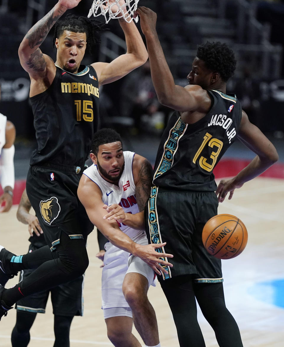 Detroit Pistons guard Cory Joseph passes as Memphis Grizzlies forward Brandon Clarke (15) and forward Jaren Jackson Jr. (13) defend during the first half of an NBA basketball game, Thursday, May 6, 2021, in Detroit. (AP Photo/Carlos Osorio)